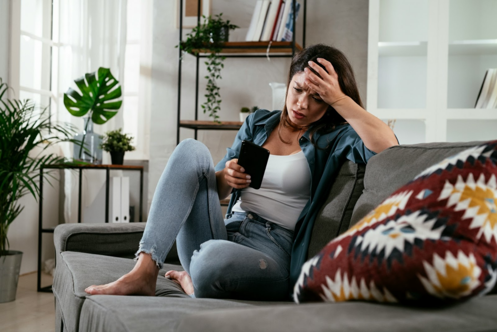 Photo by Getty A woman looks stressed whilst on her phone.